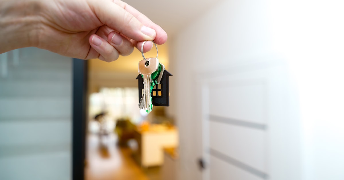 A buyer holds the keys to their newly completed home at the front entrance